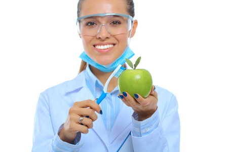 Dentist medical doctor woman hold green fresh apple in hand and tooth brushの写真素材