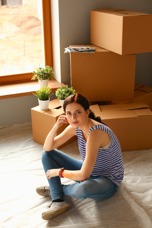 Woman in a new home with cardboard boxesの写真素材
