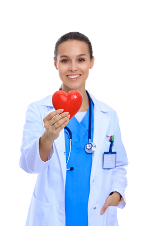 Positive female doctor standing with stethoscope and red heart symbol isolatedの写真素材