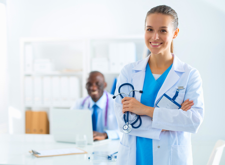 A smiling female doctor with a folder in uniform indoorsの写真素材