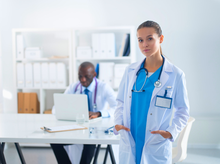 A smiling female doctor with a folder in uniform indoorsの写真素材