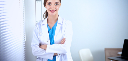 Portrait of young woman doctor with white coat standing in hospital .の写真素材