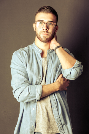 Portrait of a happy casual man standing isolated on a dark backgroundの写真素材