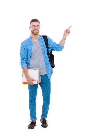 A male student with a school bag holding books and pointing isolated on white backgroundの写真素材