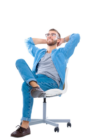Young man sitting on the chair isolated over white backgroundの写真素材