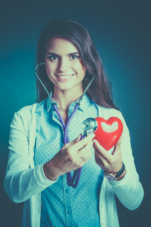 A doctor with stethoscope examining red heartの写真素材
