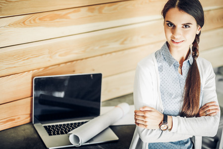 Young female standing near deskの写真素材