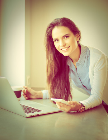 Young female standing near deskの写真素材