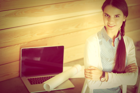 Young female standing near deskの写真素材