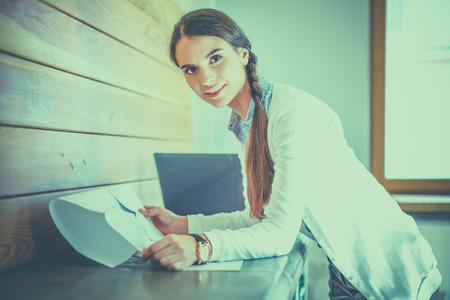 Young female standing near deskの写真素材