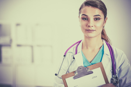 Woman doctor standing with folder at hospital .の写真素材
