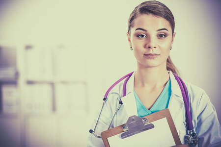 Woman doctor standing with folder at hospitalの写真素材