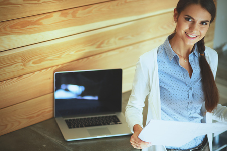 Young female standing near deskの写真素材
