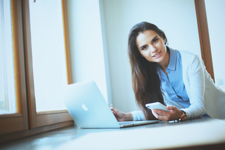 Young female standing near deskの写真素材
