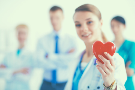 Young woman doctor holding a red heart, isolated on white background.の写真素材