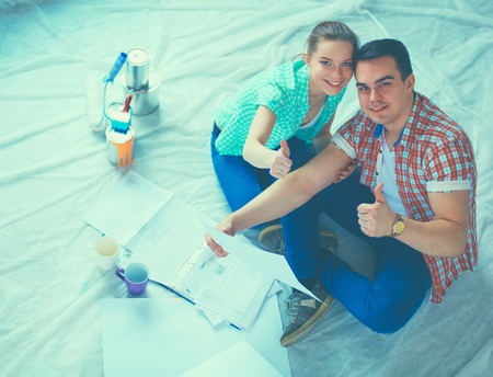 Young couple sitting on floor and calculating about they savings.の写真素材