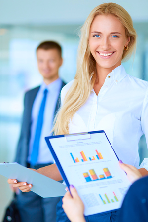 Portrait of young businesswoman in office with colleagues in the background.の写真素材