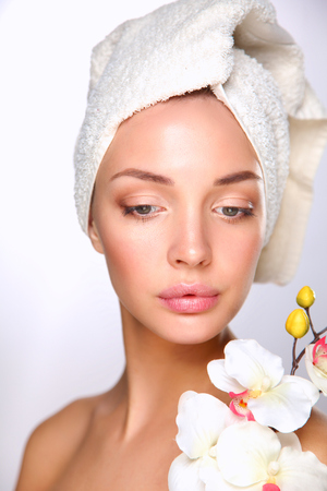 Portrait of beautiful girl touching her face with a towel on head.の写真素材