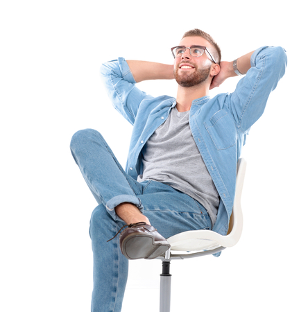 Young man sitting on the chair isolated over white background.の写真素材