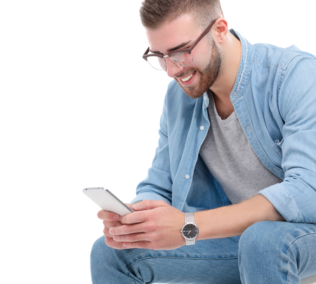 A young guy with a mobile phone, isolated on white background.の写真素材