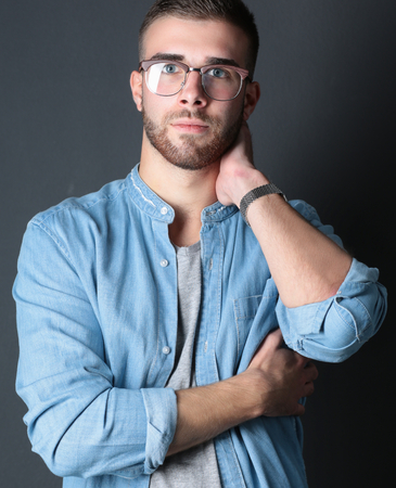 Portrait of happy casual man standing isolated on a dark background.の写真素材
