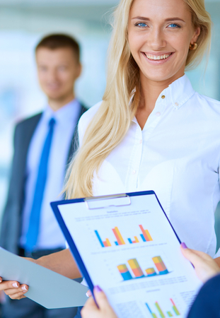 Portrait of young businesswoman in office with colleagues in the background.の写真素材