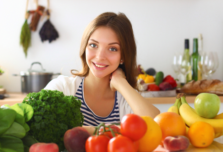 Young woman standing near desk in the kitchen.の写真素材