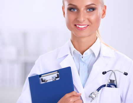 Woman doctor standing with folder at hospital.の写真素材