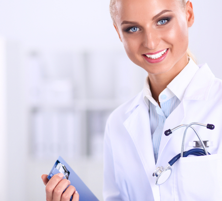 Woman doctor standing with folder at hospital.の写真素材