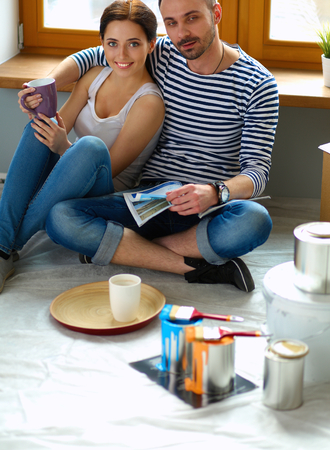 Couple moving in house sitting on the floor .の写真素材