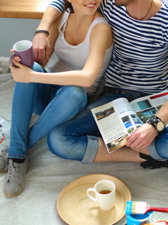 Couple moving in house sitting on the floor .の写真素材