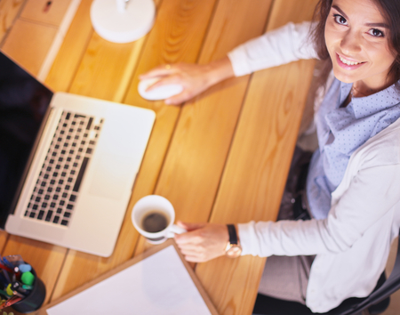 Young female entrepreneur working sitting at a deskの写真素材