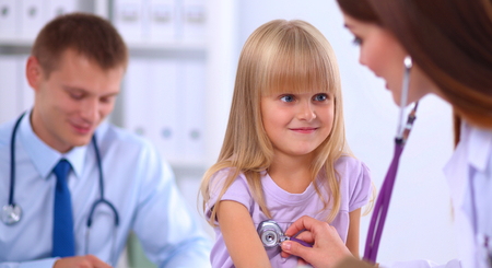 Female doctor examining child with stethoscope at surgery.の写真素材