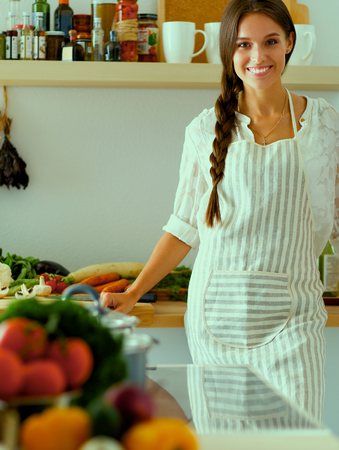 Young woman standing near desk in the kitchen.の写真素材