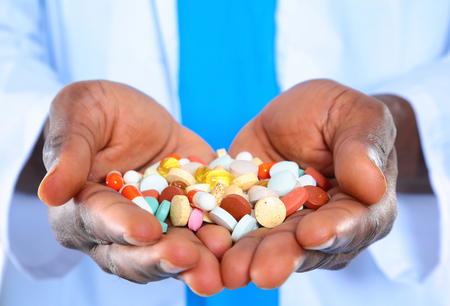pill in a hand isolated on white backgroundの写真素材