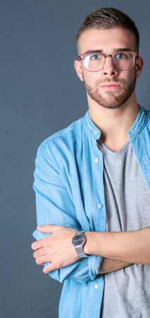 Portrait of happy casual man standing isolated on a dark background.の写真素材