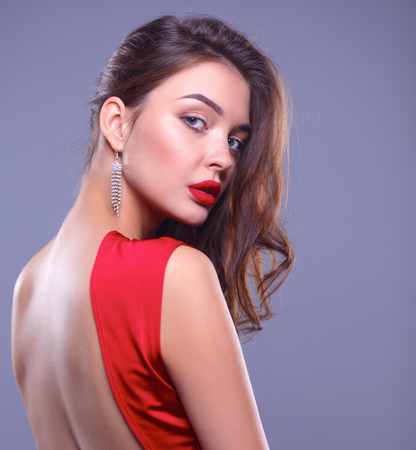 Young woman wearing a red dress standing.の写真素材