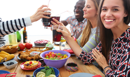 People with drinks while sitting at the dining table.の写真素材