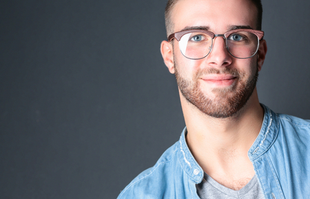 Portrait of happy casual man standing isolated on a dark background.の写真素材