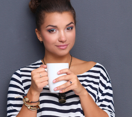 Portrait of young woman with cup tea or coffee.の写真素材