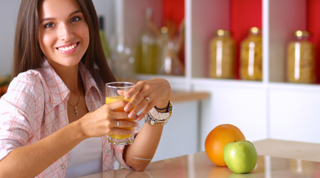 Young woman sitting a table in the kitchen.の写真素材
