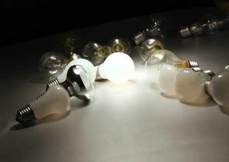 Bright light bulb , isolated in black background.の写真素材