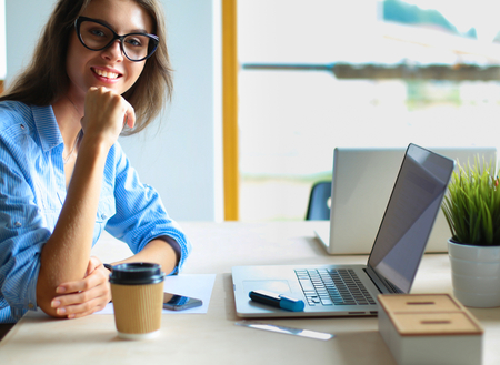 Young woman sitting at office table laptopの写真素材