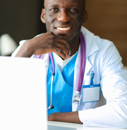 Young african doctor working on laptop at deskの写真素材