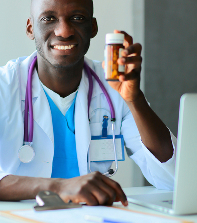 Close-up of male doctor giving jar of pills to patient.の写真素材