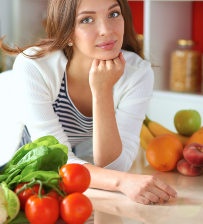 Young woman sitting near desk in the kitchen .の写真素材