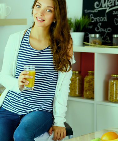 Young woman sitting near desk in the kitchen.の写真素材