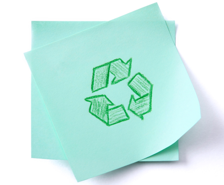 Green recycle sign on green paper isolated on white background.の写真素材