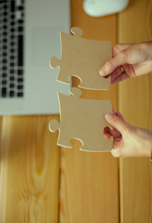 Business woman holding and pointing to a puzzle pieceの写真素材