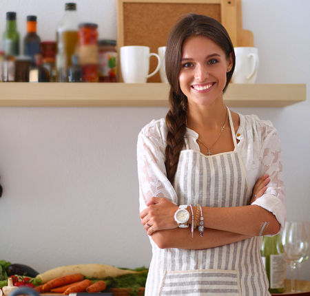 Young woman standing near desk in the kitchen.の写真素材